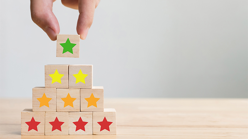 Hand putting wooden stars on the table representing score